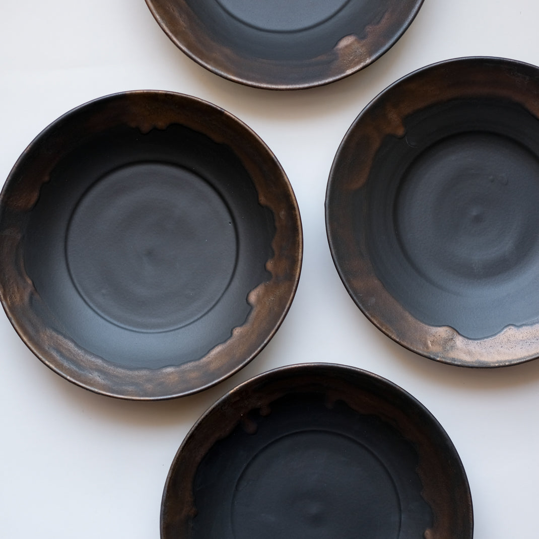 Assiette creuse noire en porcelaine par la céramiste japonaise Narumi Yashiro chez Brutal Ceramics