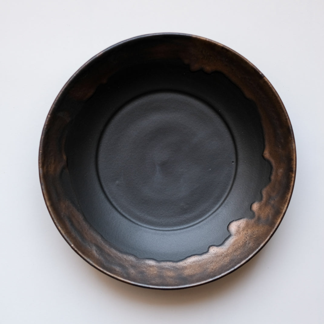 Assiette creuse noire en porcelaine par la céramiste japonaise Narumi Yashiro chez Brutal Ceramics