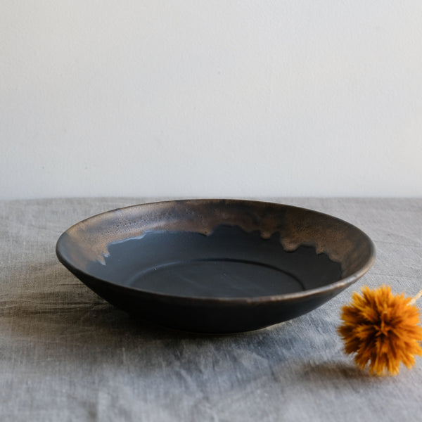 Assiette creuse noire en porcelaine par la céramiste japonaise Narumi Yashiro chez Brutal Ceramics