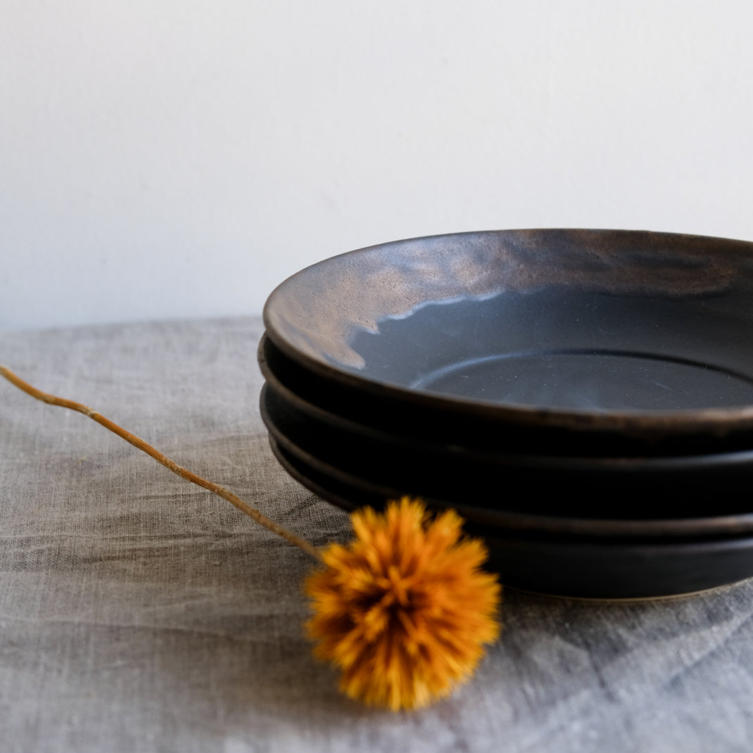 Assiette creuse noire en porcelaine par la céramiste japonaise Narumi Yashiro chez Brutal Ceramics