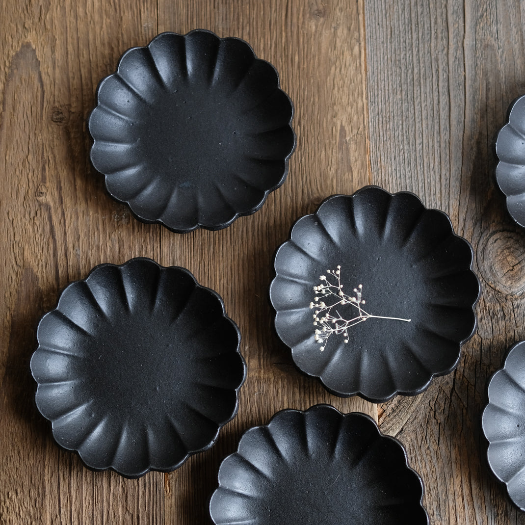 Assiette en grès noire en forme de fleur réalisée par le céramiste Shin Ito