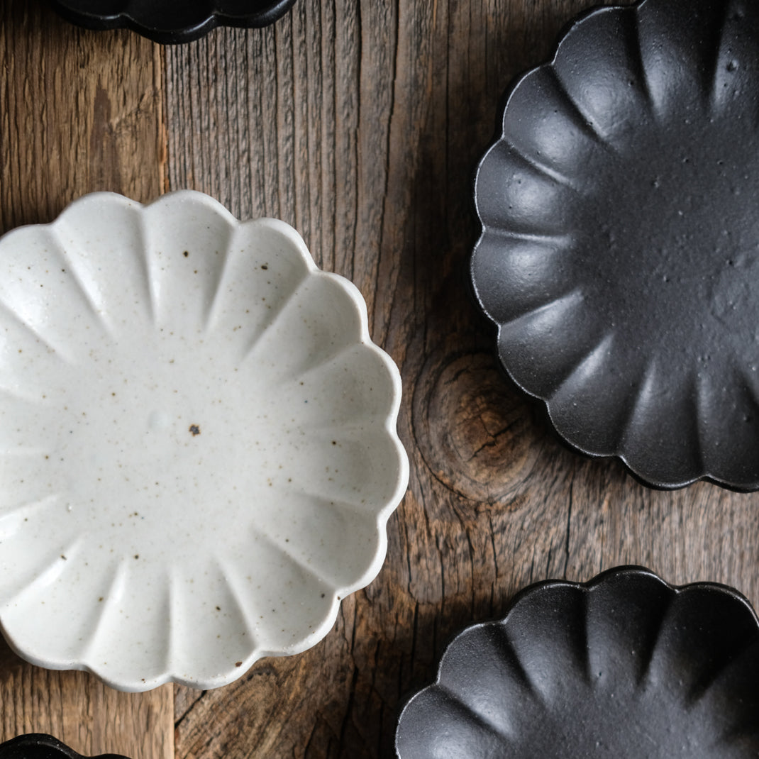 Assiette en grès noire en forme de fleur réalisée par le céramiste Shin Ito
