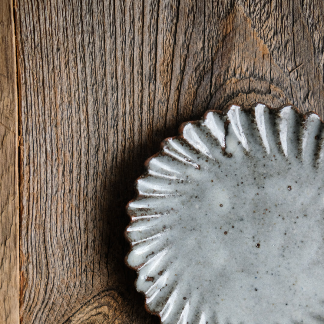 Assiette en grès grise en forme de fleur réalisée par le céramiste Shin Ito