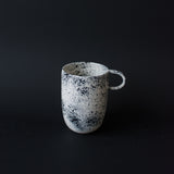 Mug noire moucheté fait à la main dans l'atelier parisien de Pia Van Peteghem, céramiste