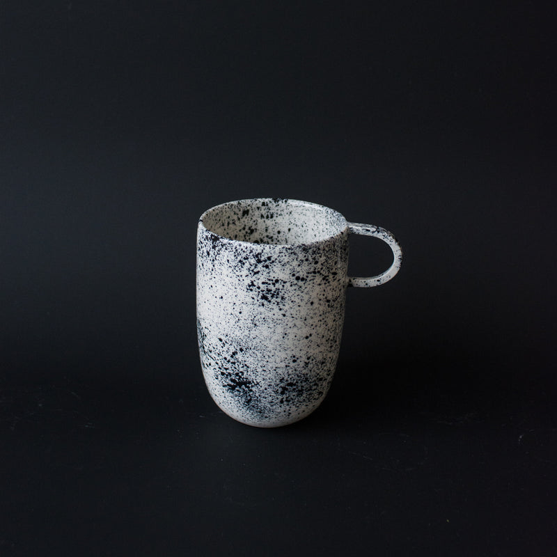 Mug noire moucheté fait à la main dans l'atelier parisien de Pia Van Peteghem, céramiste