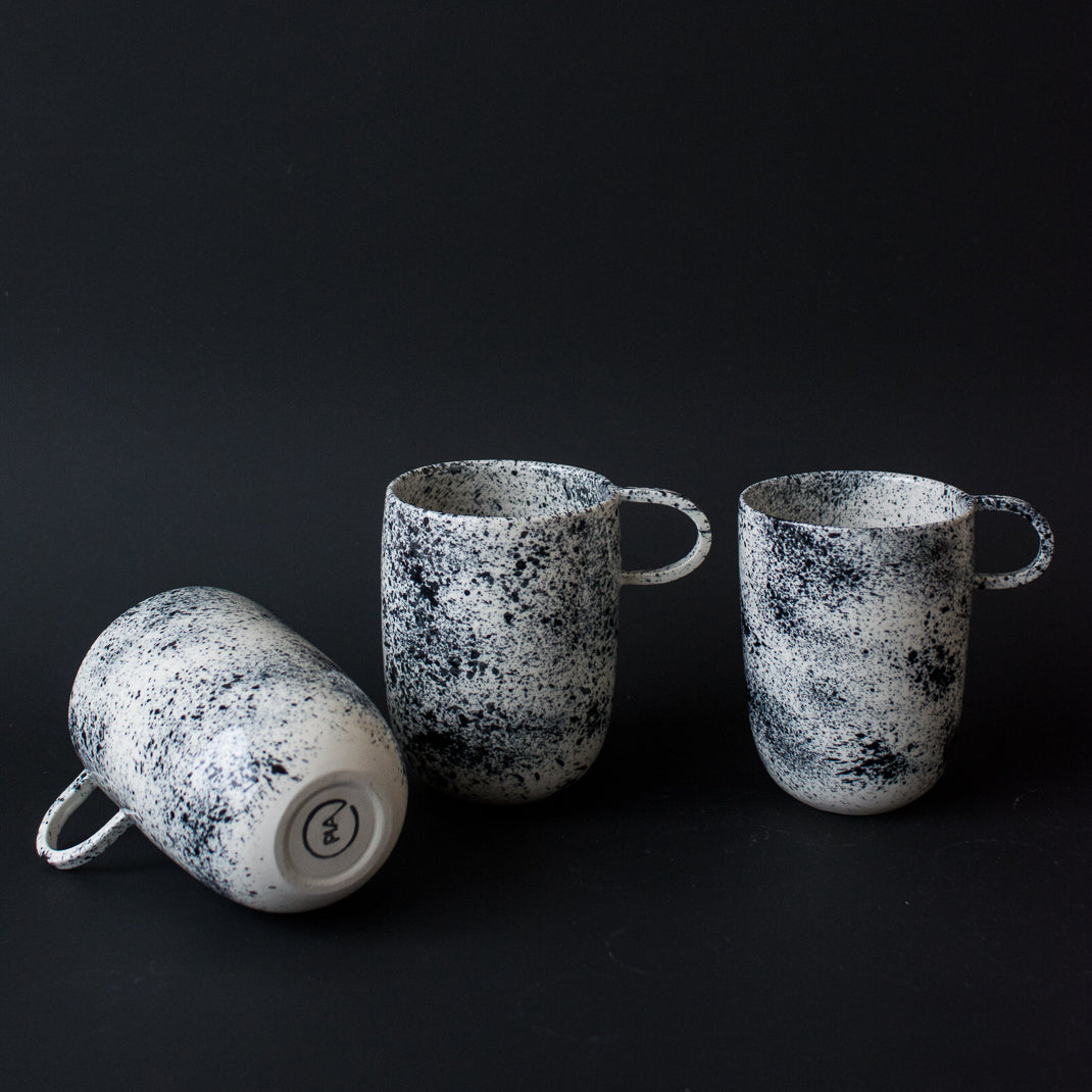 Mug noir moucheté fait à la main dans l'atelier parisien de Pia Van Peteghem, céramiste