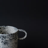 Mug noir moucheté fait à la main dans l'atelier parisien de Pia Van Peteghem, céramiste