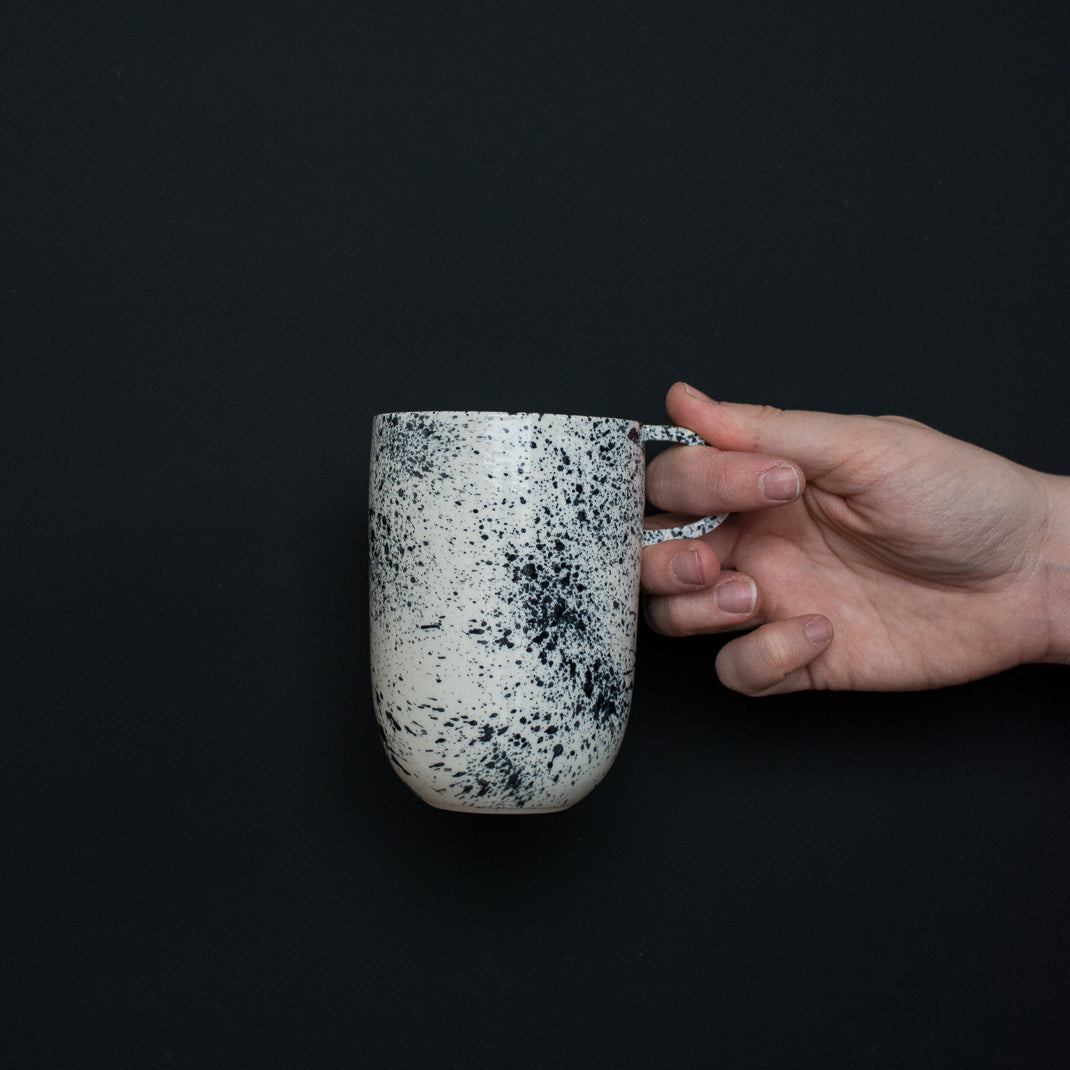 Mug noir moucheté fait à la main dans l'atelier parisien de Pia Van Peteghem, céramiste