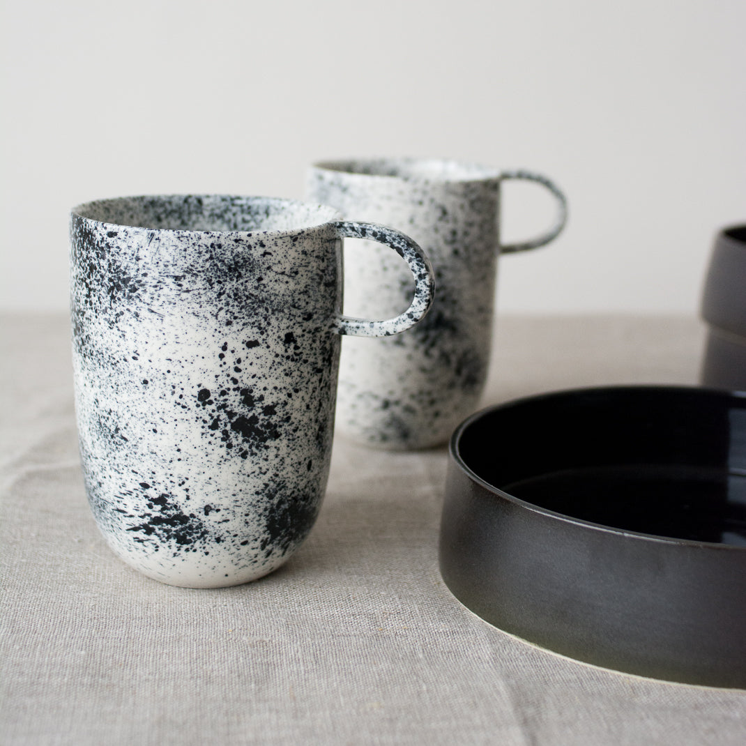 Mug noir moucheté fait à la main dans l'atelier parisien de Pia Van Peteghem, céramiste