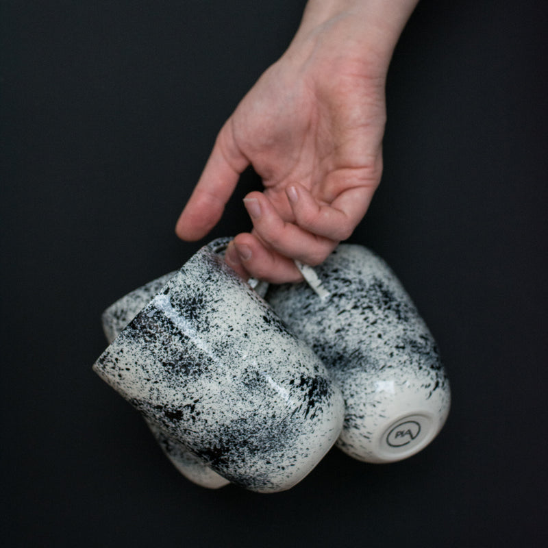 Mug noir moucheté fait à la main dans l'atelier parisien de Pia Van Peteghem, céramiste