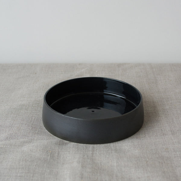Assiette creuse noire faite à la main dans l'atelier parisien de Pia Van Peteghem, céramiste