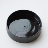 Assiette creuse noire faite à la main dans l'atelier parisien de Pia Van Peteghem, céramiste