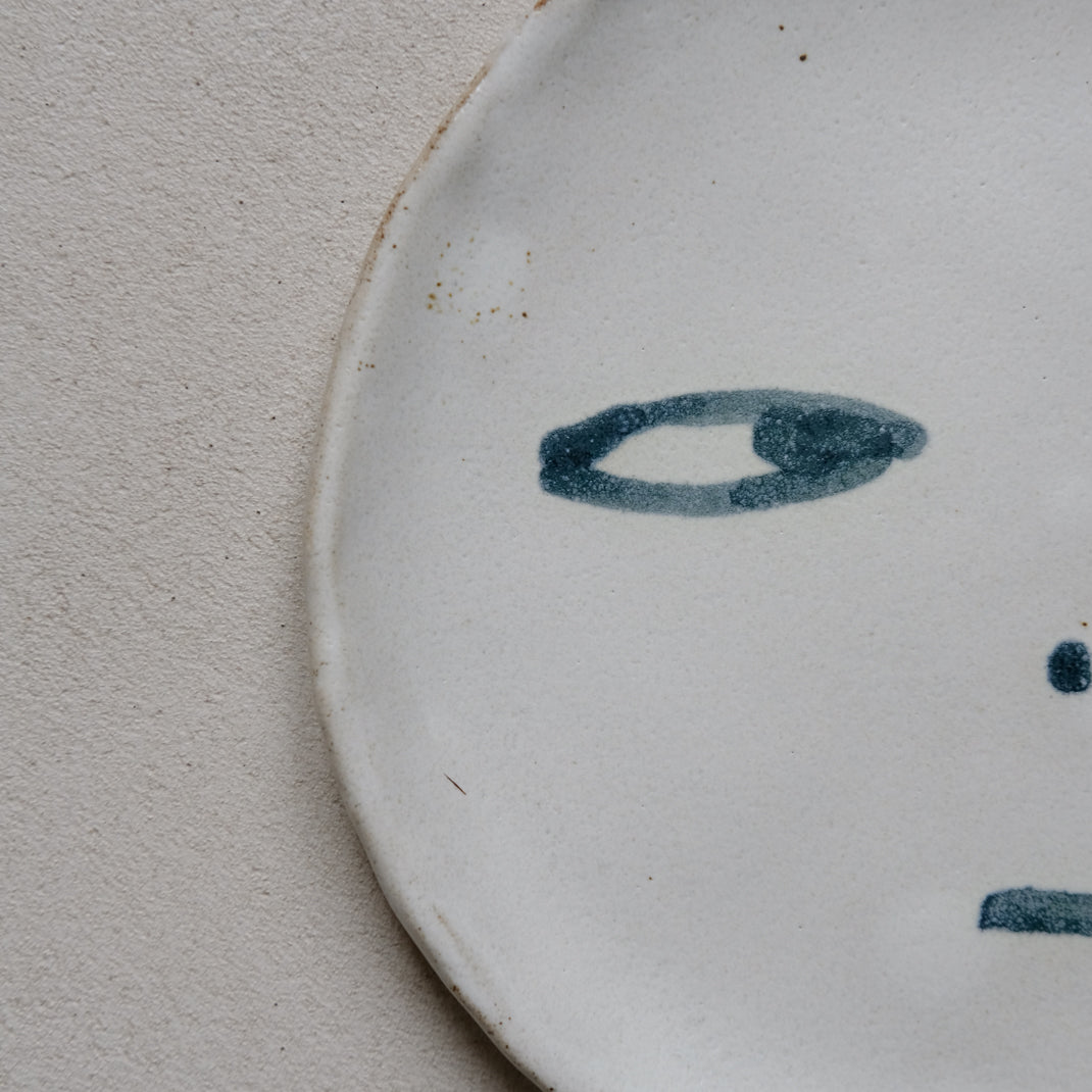 Plate in black stoneware face of Madoka Rindal at Brutal Ceramics