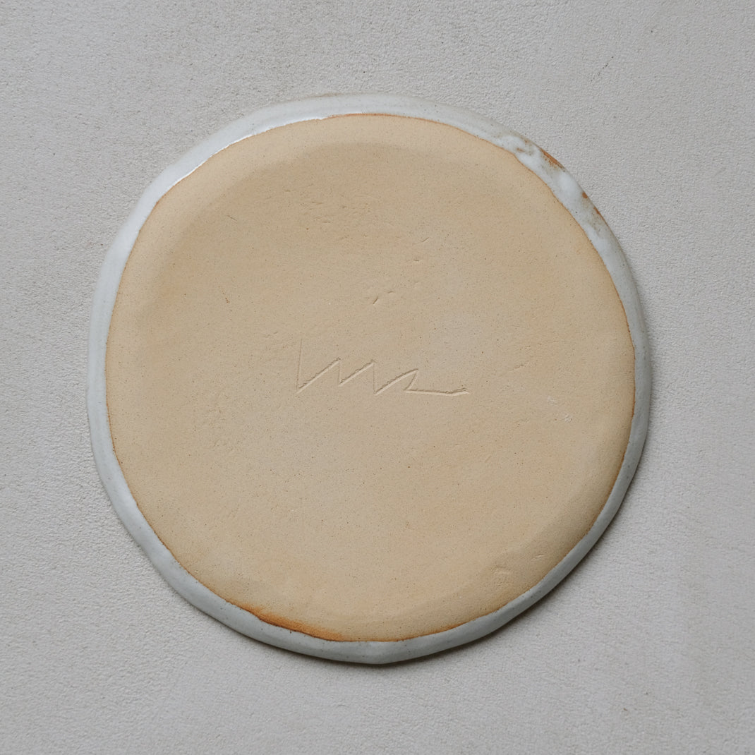 Plate in black stoneware face of Madoka Rindal at Brutal Ceramics