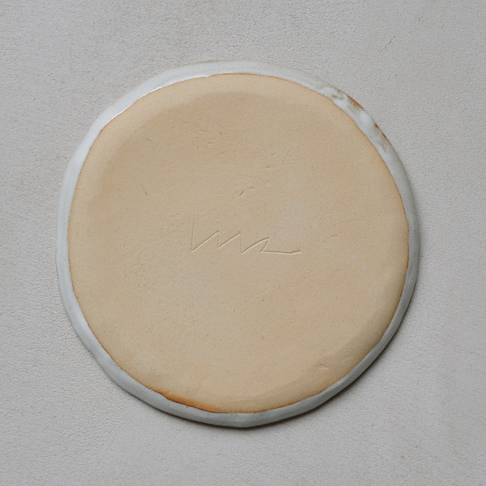Plate in black stoneware face of Madoka Rindal at Brutal Ceramics