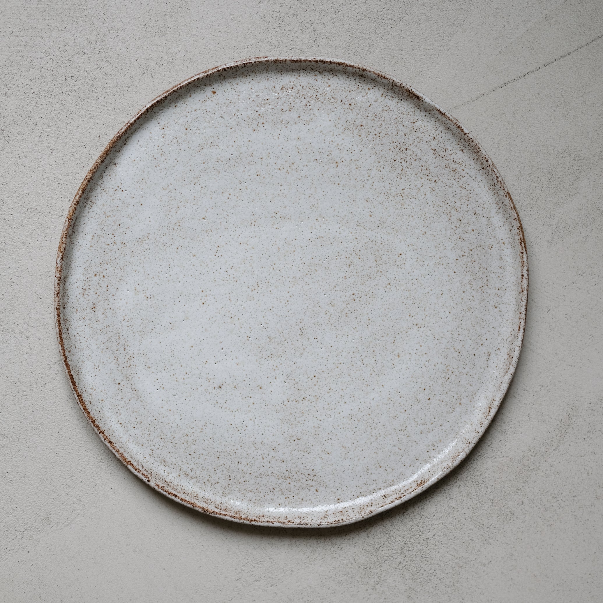 Assiette en grès gris, blanc moucheté d'Anne Marie Peters, Brutal Ceramics