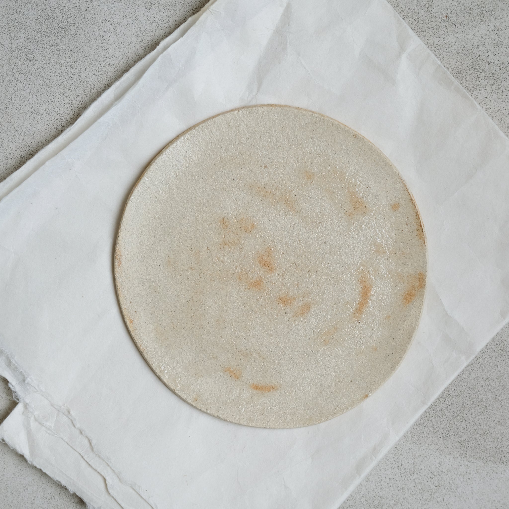 Assiette ultra plate en grès blanc de Judith Lasry chez Brutal 