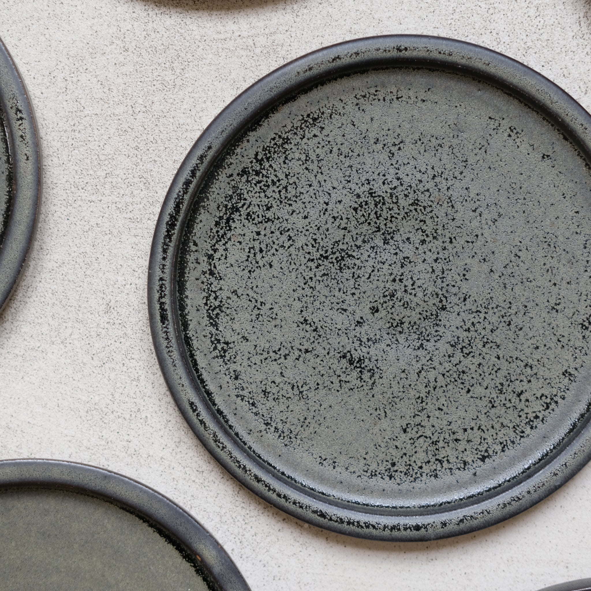 Assiette en grès noir mouchetée par Léa Guetta chez Brutal Ceramics