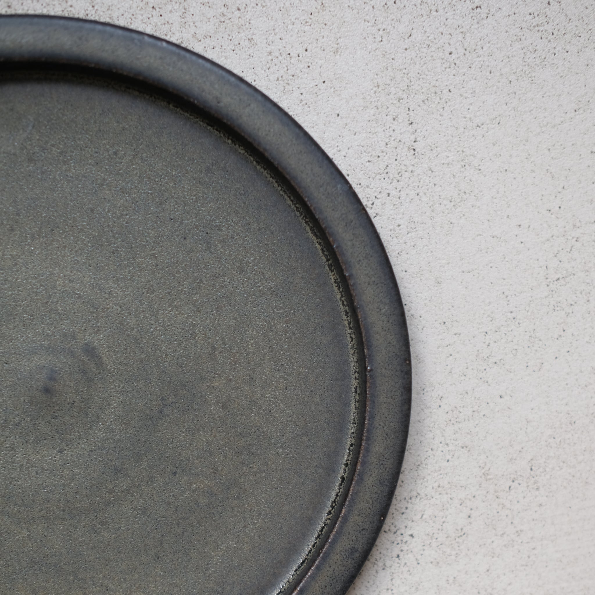 Assiette en grès noir mouchetée par Léa Guetta chez Brutal Ceramics