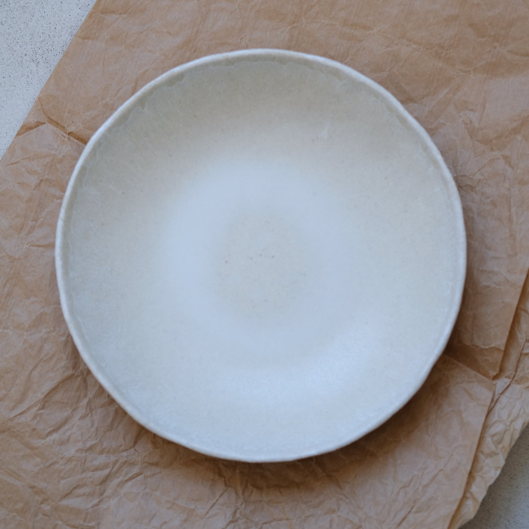 Assiette creuse en grès blanc de Lola Moreau chez Brutal Ceramics