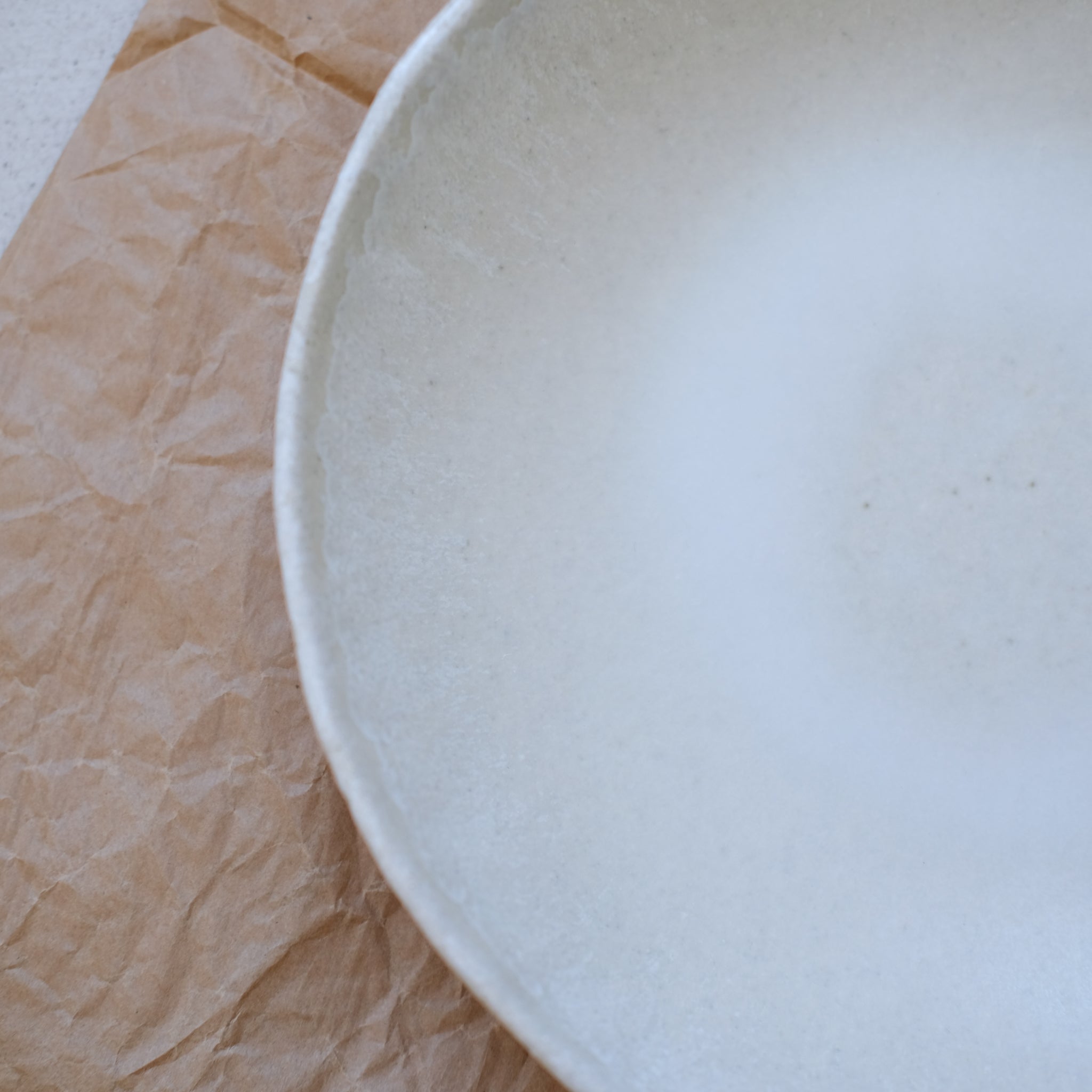 Assiette creuse en grès blanc de Lola Moreau chez Brutal Ceramics