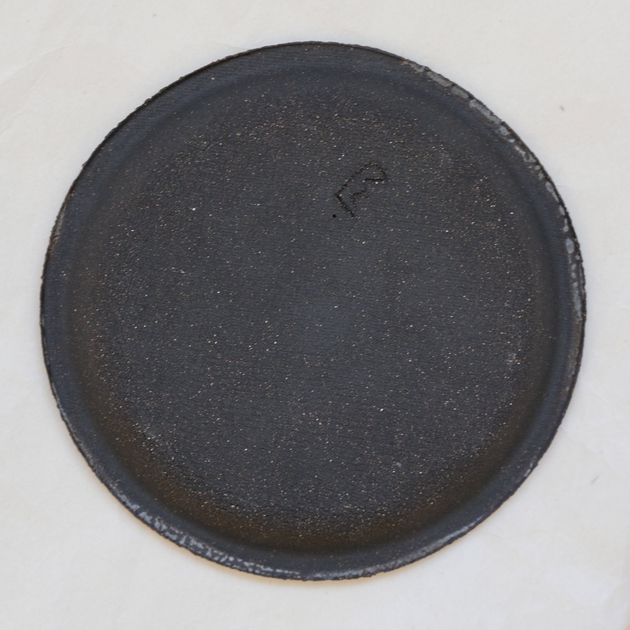 Assiette en grès noir texturée par Mano Mani chez Brutal Ceramics