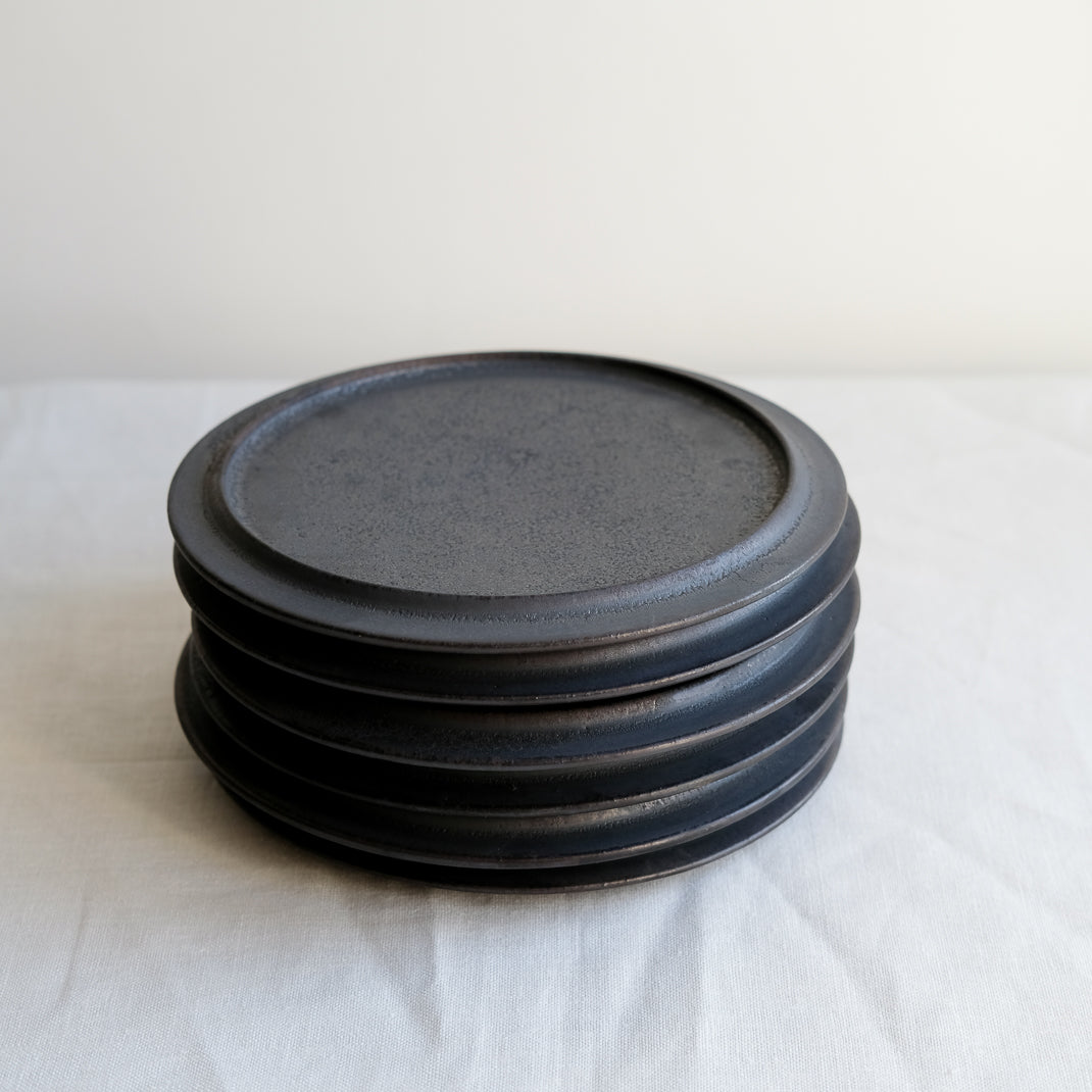 les assiettes noires du potier japonais Atsushi Funakushi