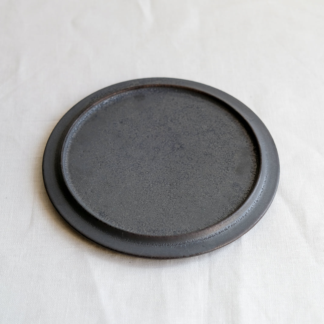 les assiettes noires du potier japonais Atsushi Funakushi