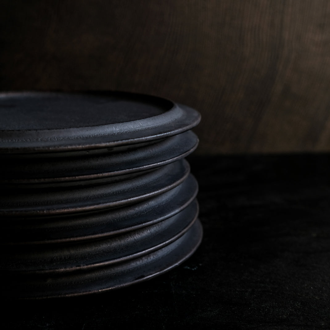 les assiettes noires du potier japonais Atsushi Funakushi