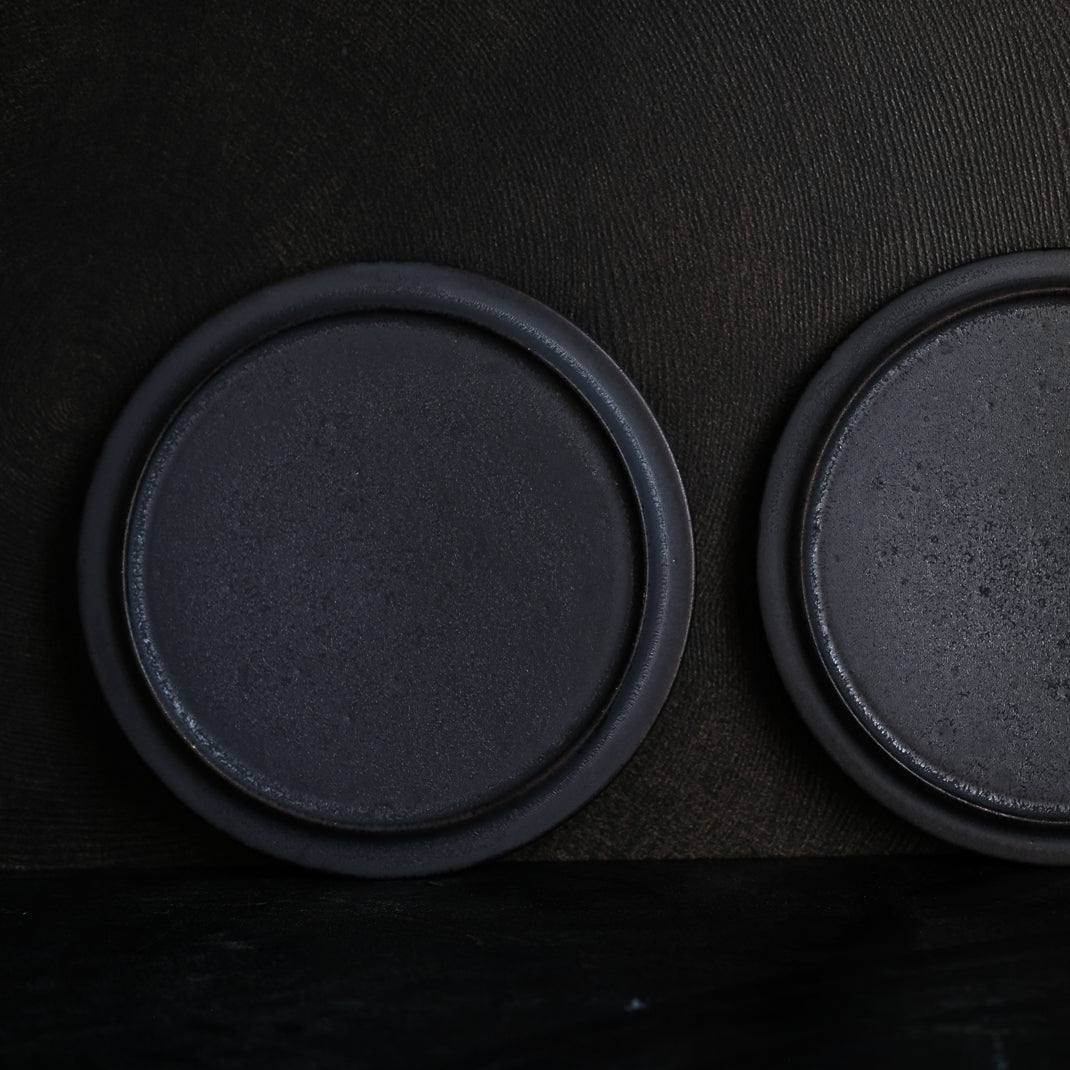 les assiettes noires du potier japonais Atsushi Funakushi