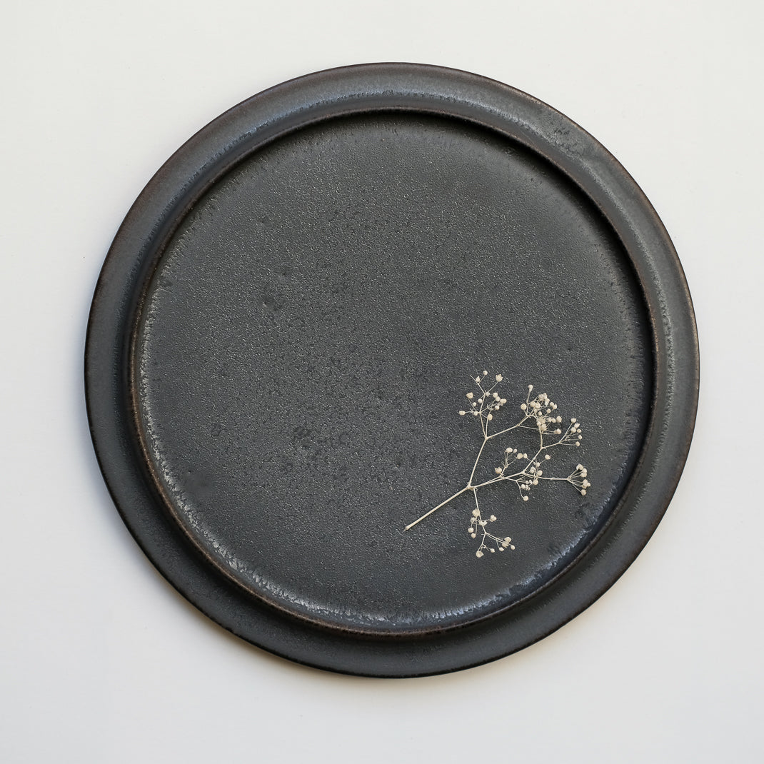 les assiettes noires du potier japonais Atsushi Funakushi