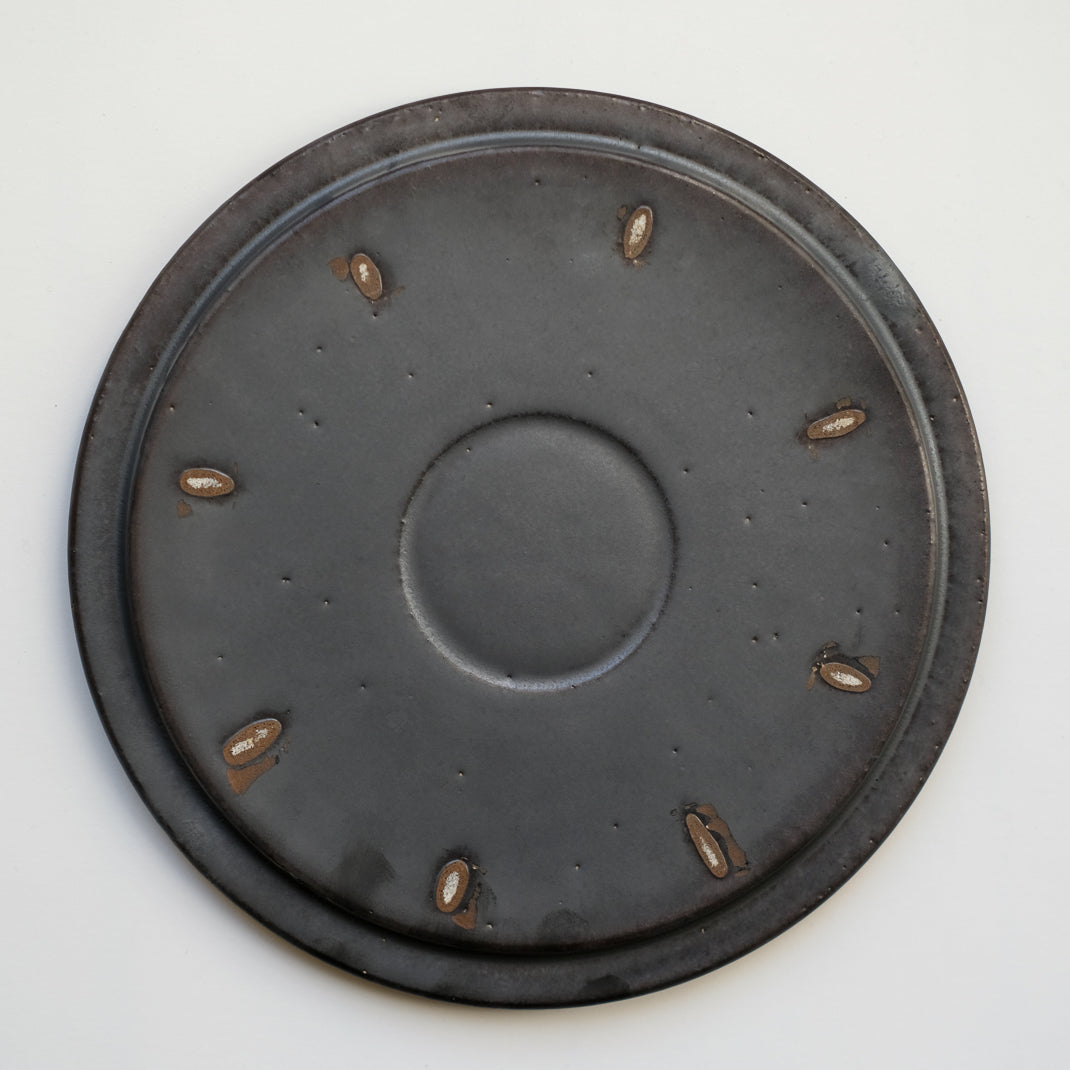 les assiettes noires du potier japonais Atsushi Funakushi