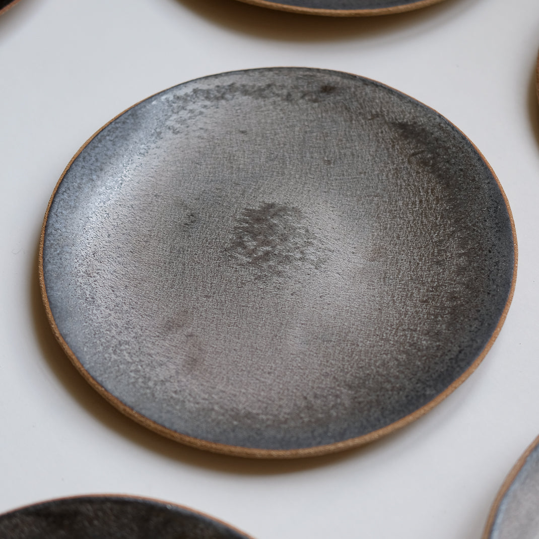 Assiette issue de la collection Sand en noir argenté par Lisa Allegra dans son atelier de Barcelone en Espagne