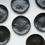 Assiette à entrée/dessert en grès noir réalisée à la main par la céramiste Judith Lasry dans son atelier en bourgogne, pour Brutal Ceramics