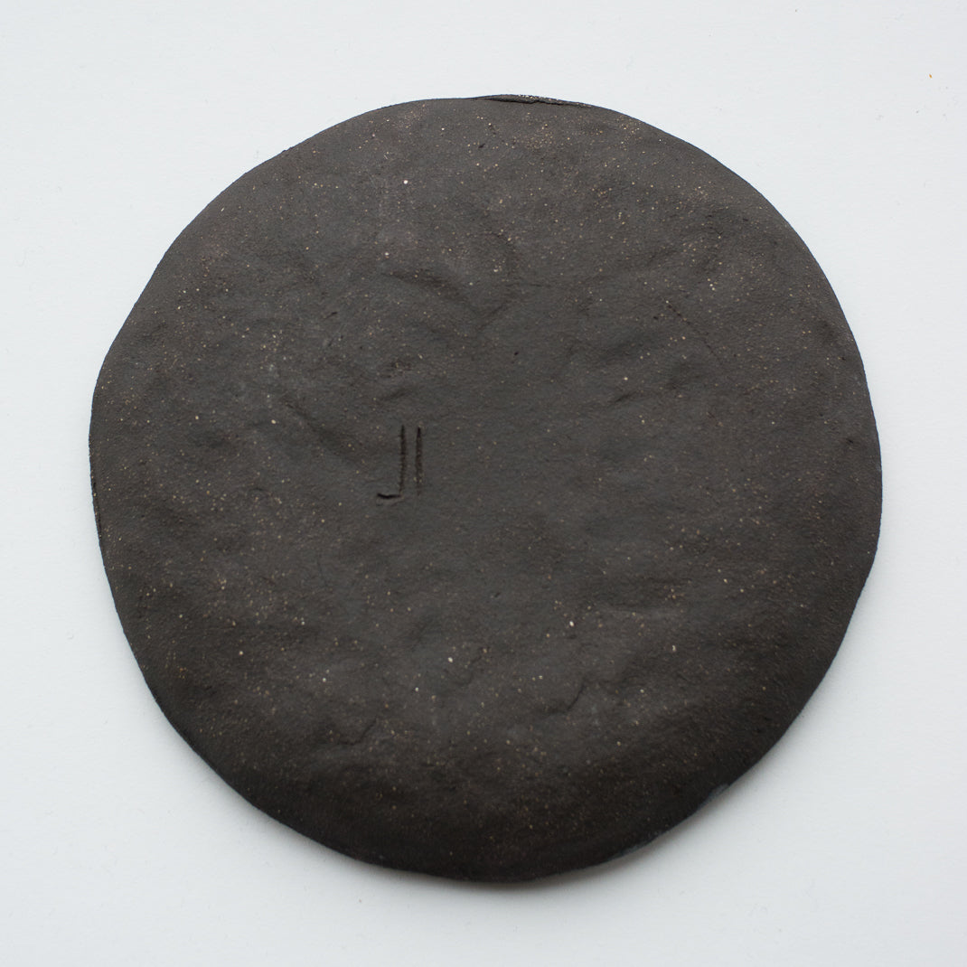 Assiette à entrée/dessert en grès noir réalisée à la main par la céramiste Judith Lasry dans son atelier en bourgogne, pour Brutal Ceramics