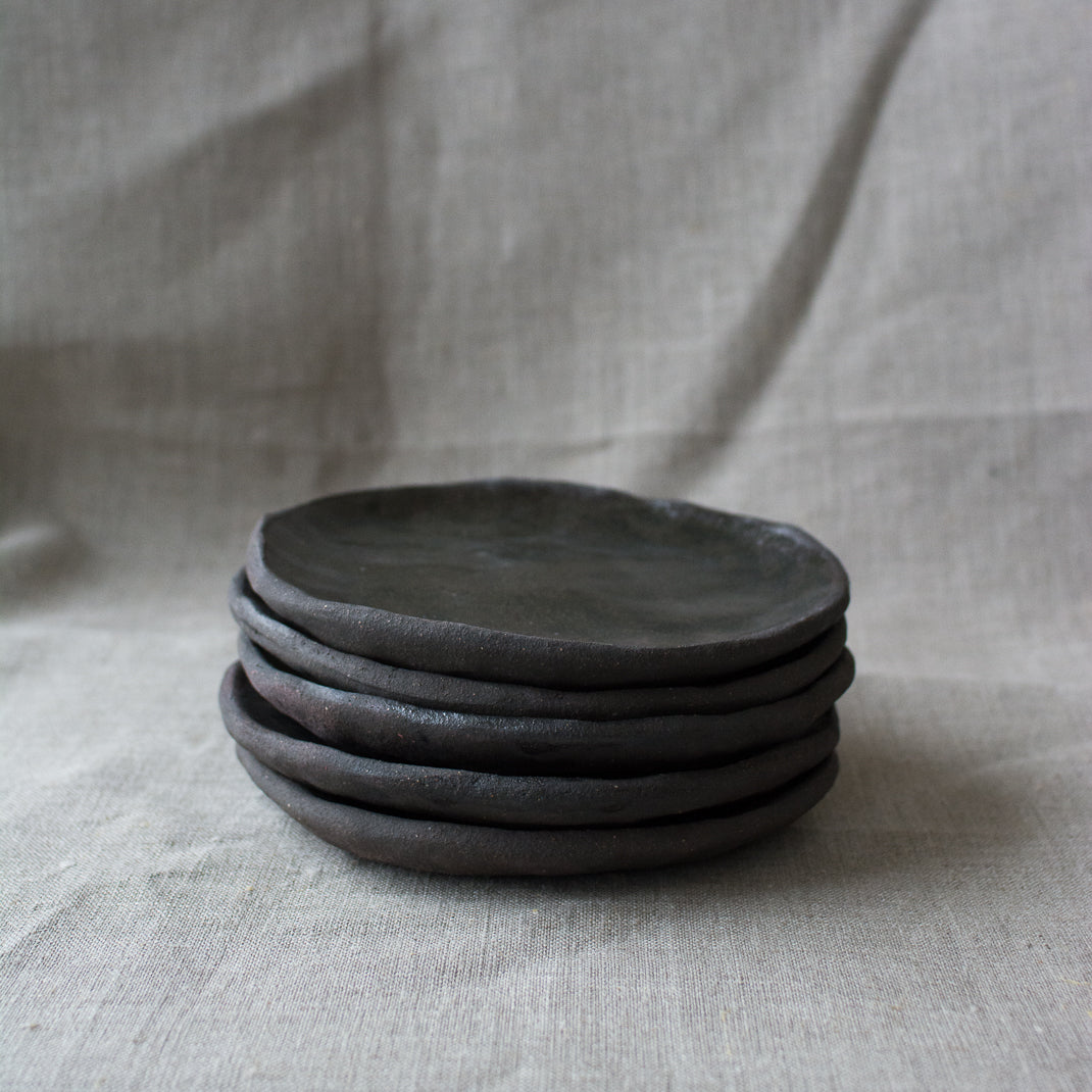 Assiette à entrée/dessert en grès noir réalisée à la main par la céramiste Judith Lasry dans son atelier en bourgogne, pour Brutal Ceramics