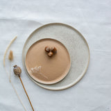 Assiette en grès émaillé blanc moucheté de Laurette Broll, céramiste