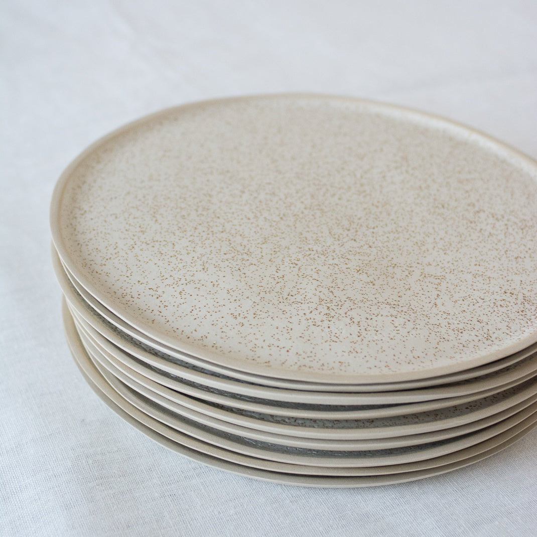 Assiette en grès émaillé blanc moucheté de Laurette Broll, céramiste